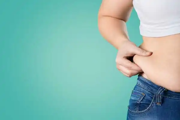 Image of woman pinching her love handles to show weight gain Mickleover